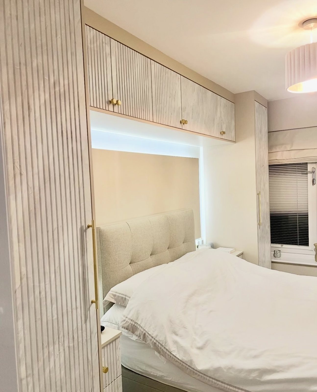 Fluted overbed units and wardrobes we fitted, with gold handles and lighting over the bed