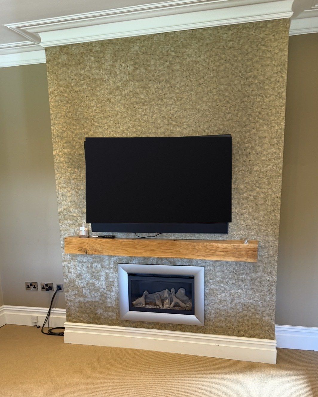The room before: TV on a chimney breast with an oak beam mantel and an inset gas fire