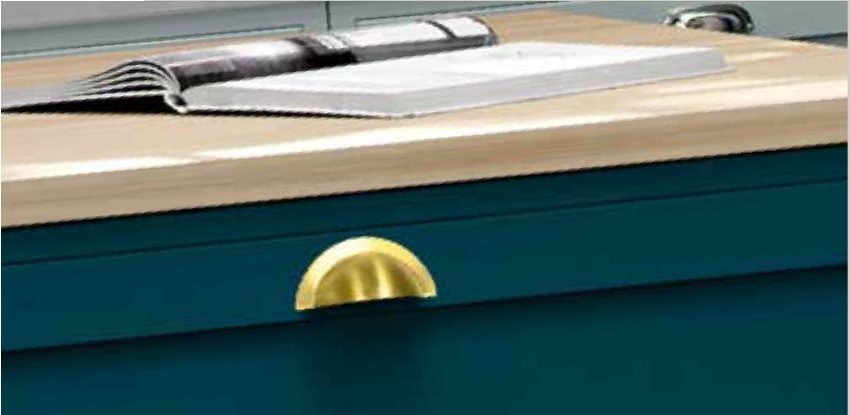 Brass cup handle on a teal drawer